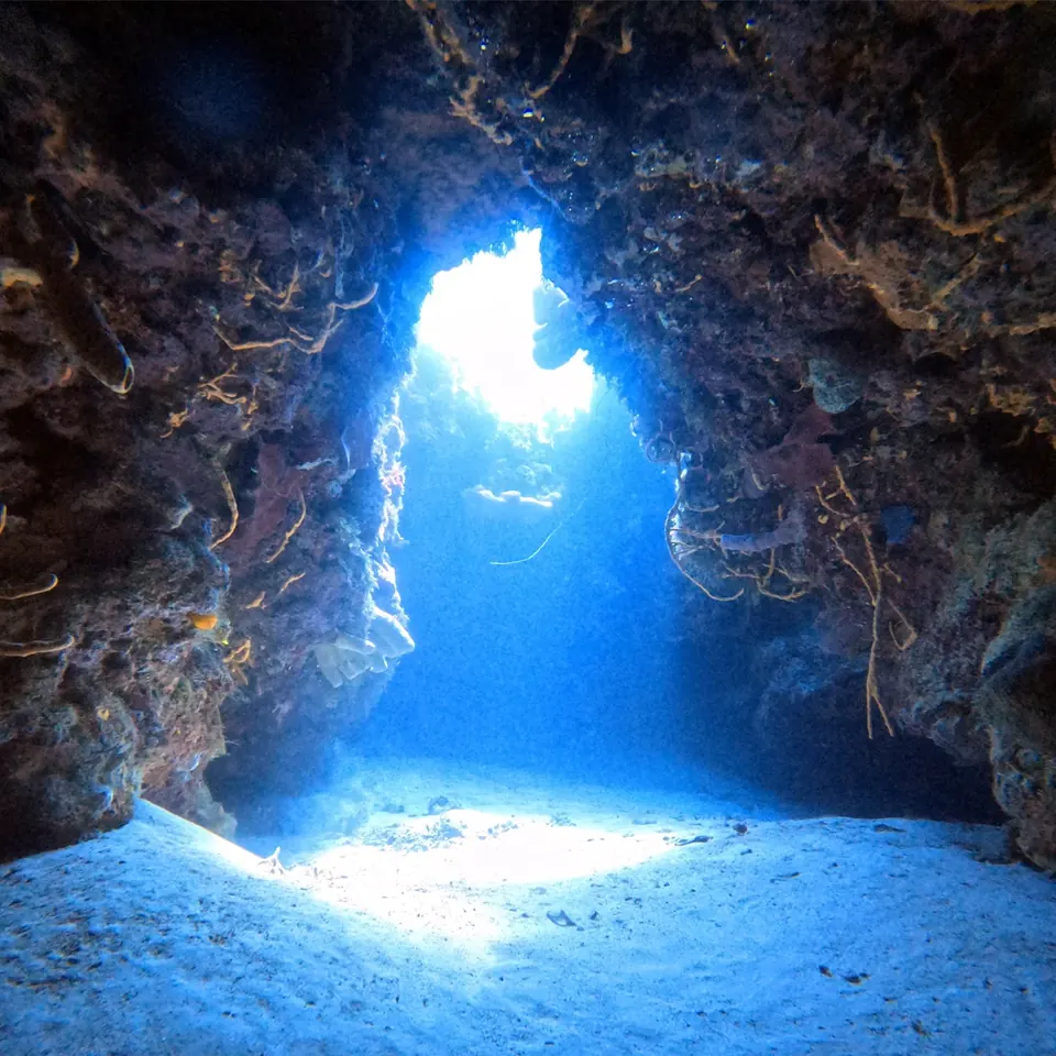 Looking out of a coral swim-through to the bright blue on the Cozumel reef