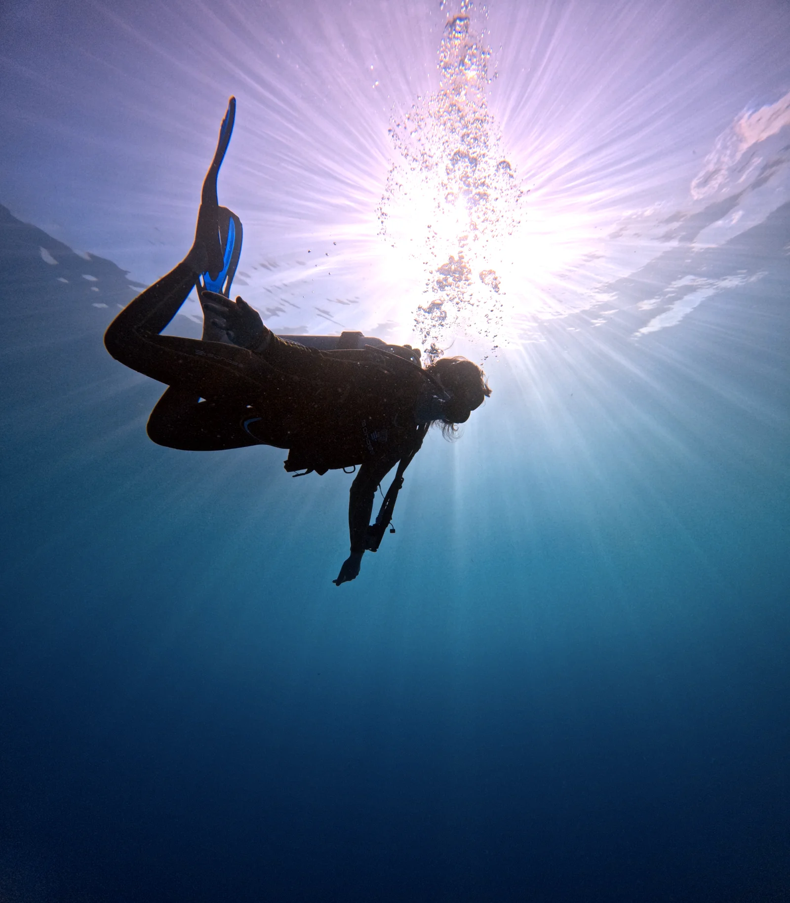 Rescue Diver student silhouetted against the sun near the surface