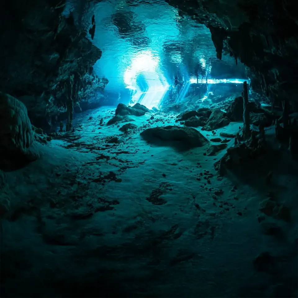 Dark cavern of Cenote Angelita lit from the distant entrance